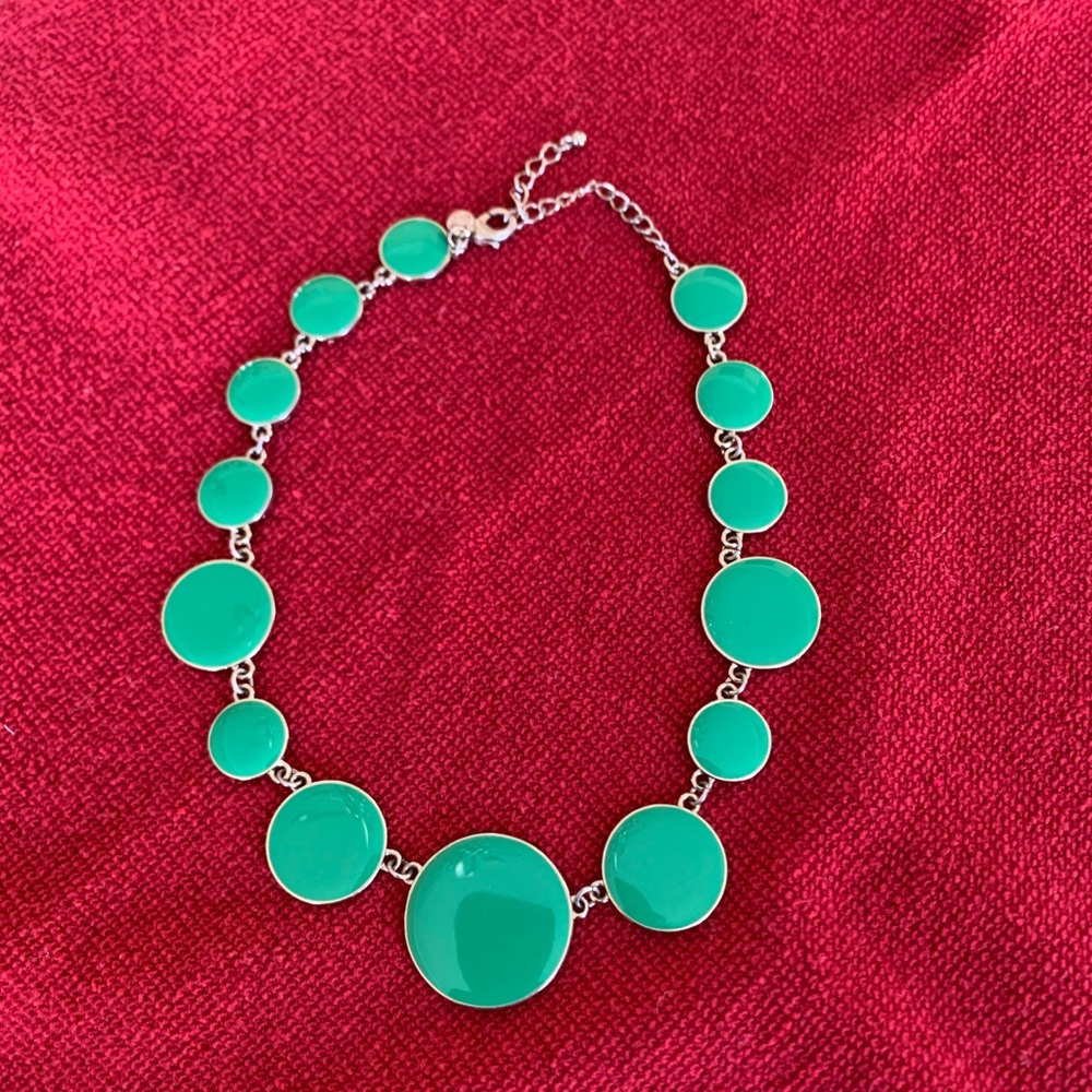 Gold necklace with green circles.